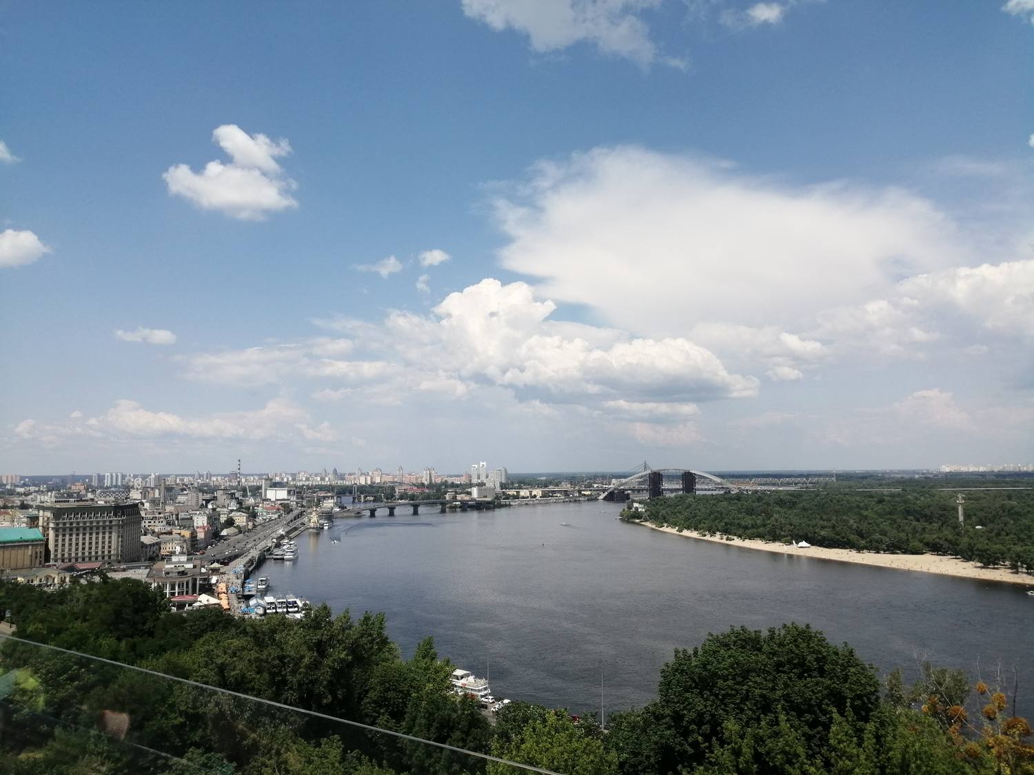 The Dnipro river curving past Kyiv under a bright summer sky